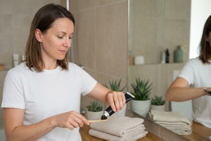 Jeune femme en salle de bain avec dentifrice charbon