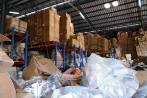 déchets de commerces stockés dans un hangar avec des emballages plastique à l'avant plan