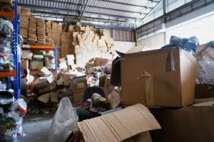 déchets de commerces stockés dans un hangar avec des cartons à l'avant plan