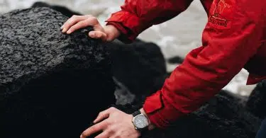 person in red jacket wearing silver and black watch